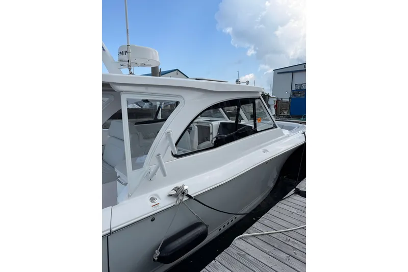 Slide: The Image of 2024 Southport 33 DC boat docked, showcasing sleek design and modern features. - 8