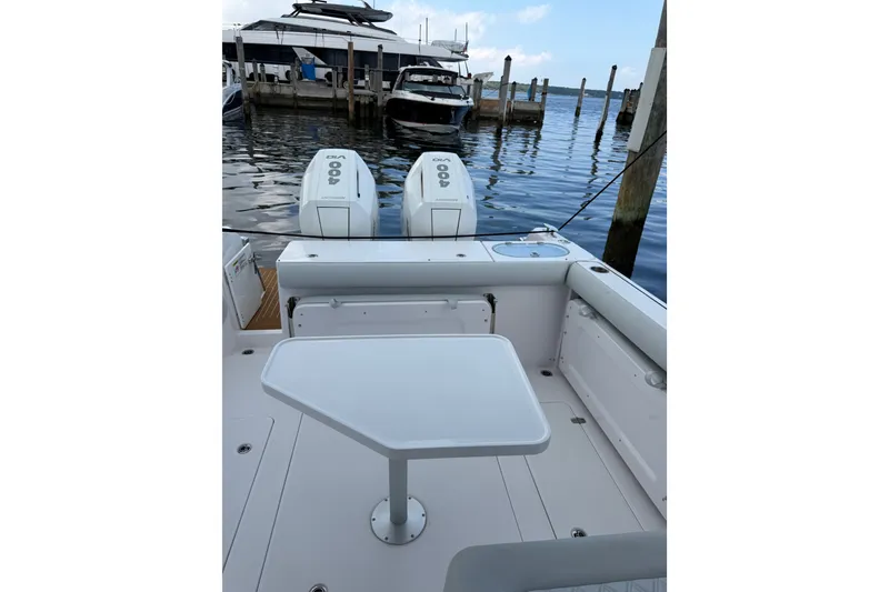 Slide: The Image of 2024 Southport 33 DC boat with dual outboard engines docked at marina. - 13