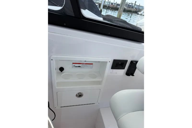Slide: The Image of 2024 Southport 33 DC boat interior with storage compartment and control panel. - 23