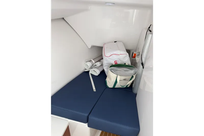 Slide: The Image of 2024 Southport 33 DC cabin interior with blue cushions and storage bags. - 26