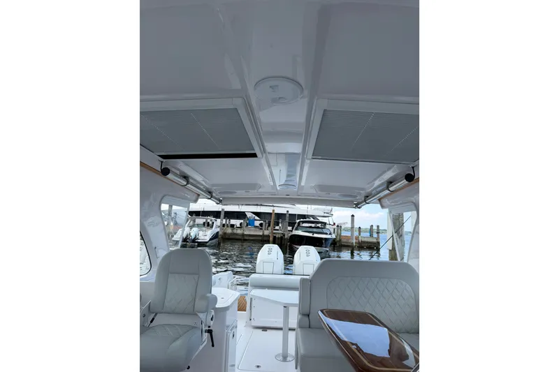 Slide: The Image of Interior view of 2024 Southport 33 DC boat at a marina, featuring seating and helm. - 11