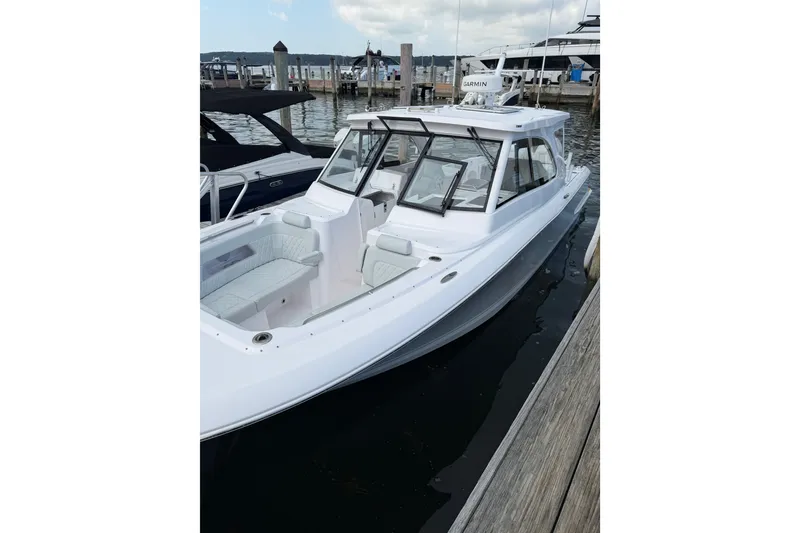 Slide: The Image of 2024 Southport 33 DC boat docked, featuring sleek design and spacious seating. - 6