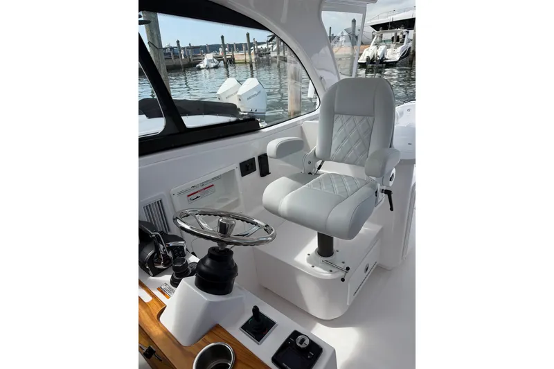 Slide: The Image of Captain's chair and helm of 2024 Southport 33 DC boat, docked at marina. - 9