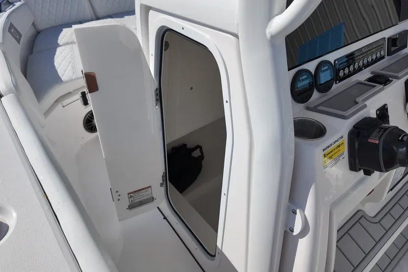 Slide: The Image of 2027 Sea Fox 228 Commander boat console with open storage compartment and seating area. - 13