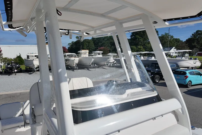 Slide: The Image of 2027 Sea Fox 228 Commander boat with T-top and windshield, parked in a marina. - 12