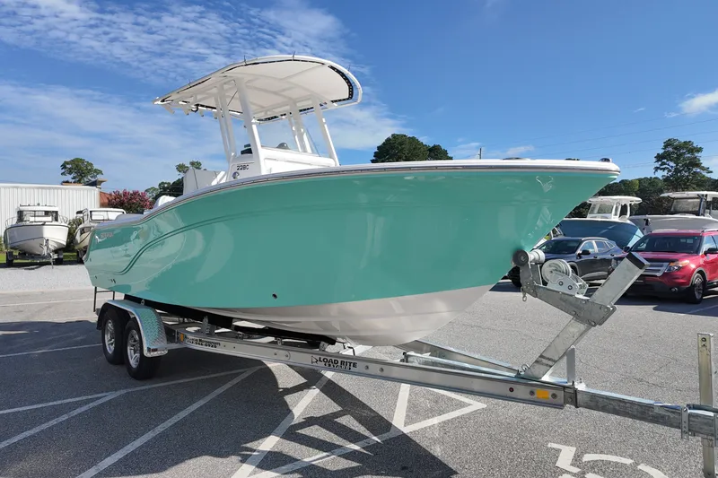 Slide: The Image of 2027 Sea Fox 228 Commander boat on trailer in parking lot under clear sky. - 2