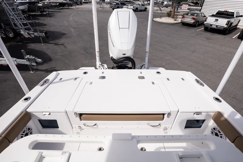 Slide: The Image of 2026 Blackfin 262 HB boat deck with outboard motor, parked in a marina. - 15
