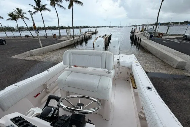 Slide: The Image of 2003 Grady-White Advance 257 boat at dock, overlooking a scenic waterfront with palm trees. - 11