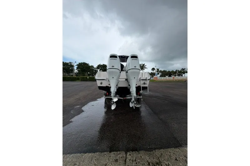 Slide: The Image of 2003 Grady-White Advance 257 boat with twin outboard motors on wet pavement. - 14
