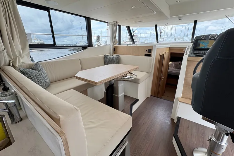 Slide: The Image of Interior of 2025 Beneteau Swift Trawler 48, featuring a modern dining area and helm station. - 15
