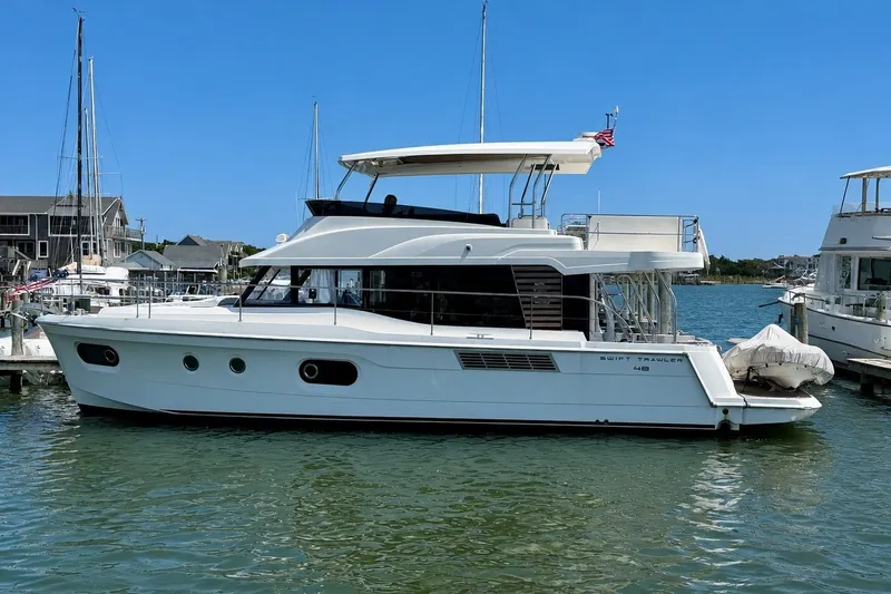 The Image of 2025 Beneteau Swift Trawler 48 docked in a marina, side view. - 0