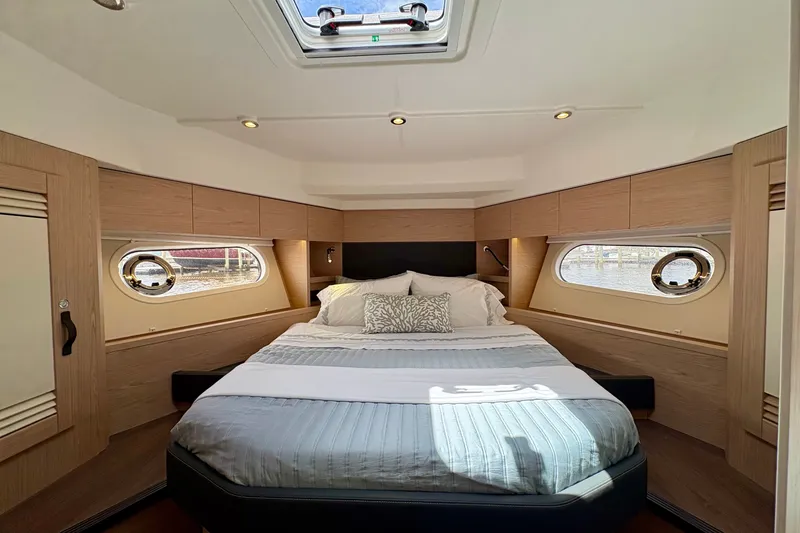Slide: The Image of Luxurious cabin interior of 2025 Beneteau Swift Trawler 48 with elegant bedding and natural light. - 6