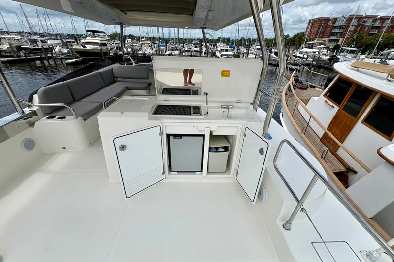 Slide: The Image of Flybridge of 2025 Beneteau Swift Trawler 48 with seating and kitchenette at marina. - 27