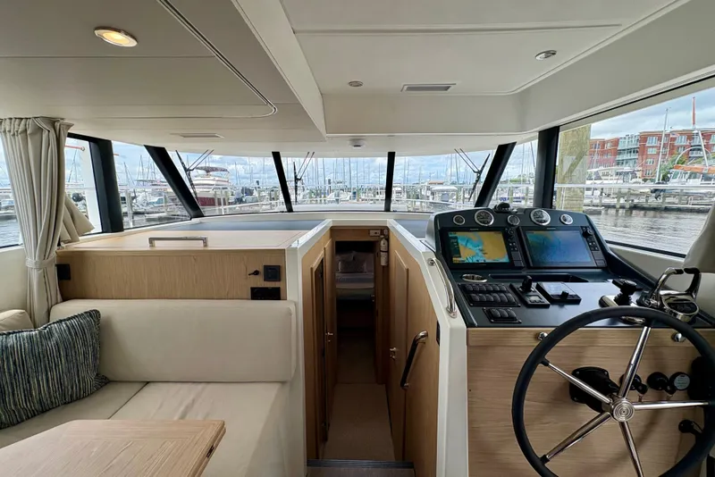 Slide: The Image of Interior of 2025 Beneteau Swift Trawler 48, featuring helm station and panoramic windows. - 4