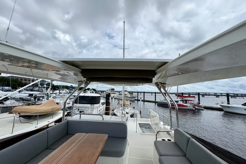 Slide: The Image of 2025 Beneteau Swift Trawler 48, spacious deck view at marina, cloudy sky backdrop. - 32