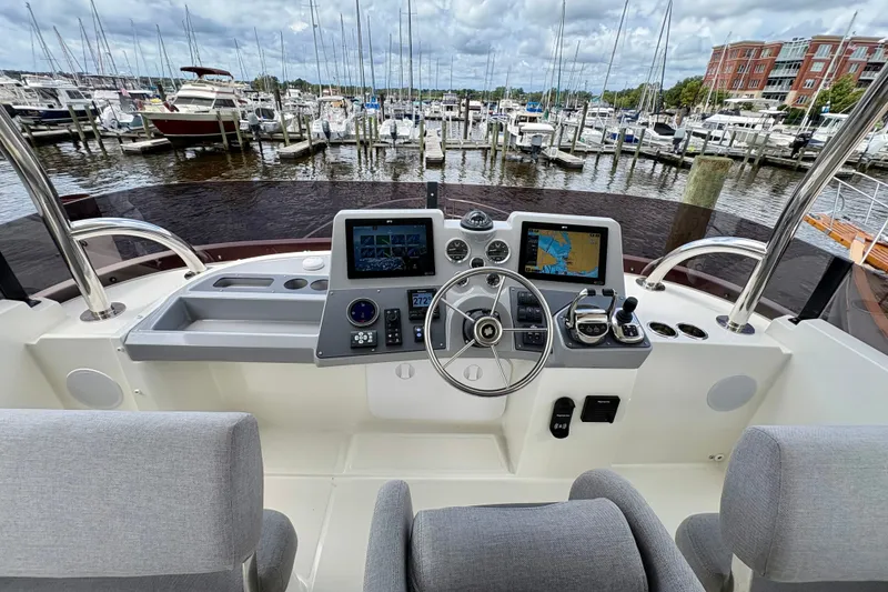 Slide: The Image of Helm of 2025 Beneteau Swift Trawler 48 with navigation screens and controls. - 28