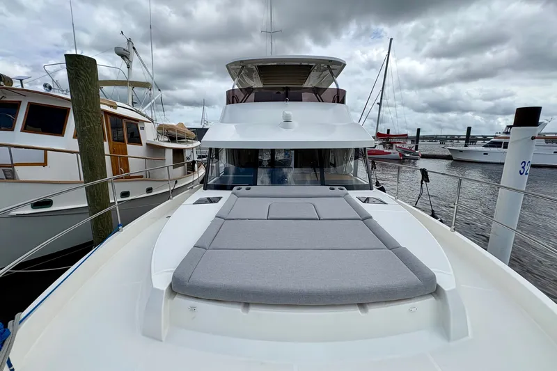 Slide: The Image of 2025 Beneteau Swift Trawler 48 docked, showcasing spacious deck and sleek design. - 21