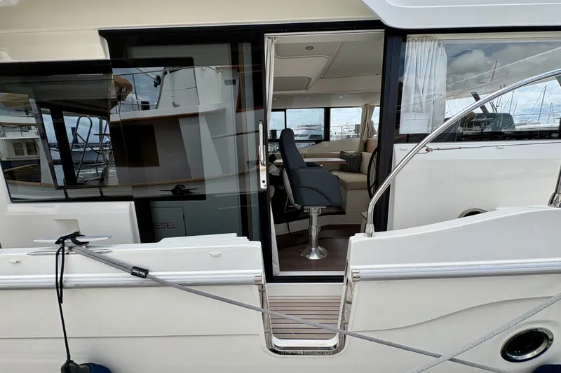 Slide: The Image of 2025 Beneteau Swift Trawler 48 interior view with seating and helm station. - 23