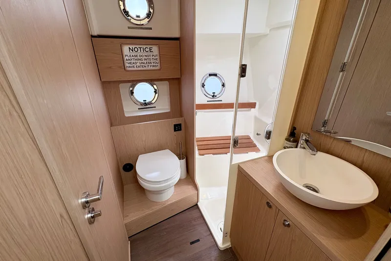 Slide: The Image of 2025 Beneteau Swift Trawler 48 bathroom with modern fixtures and wooden accents. - 9