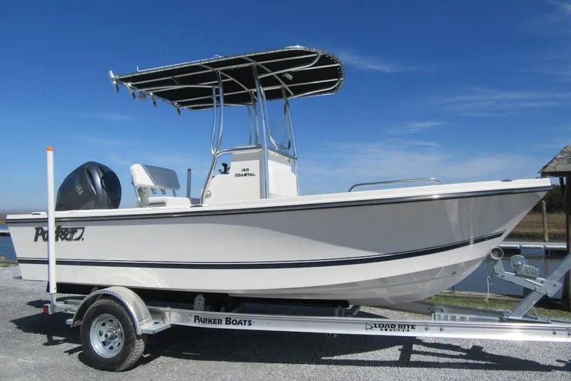 The Image of A 2027 Parker 180 Coastal boat on a trailer, featuring a T-top and outboard motor. - 1
