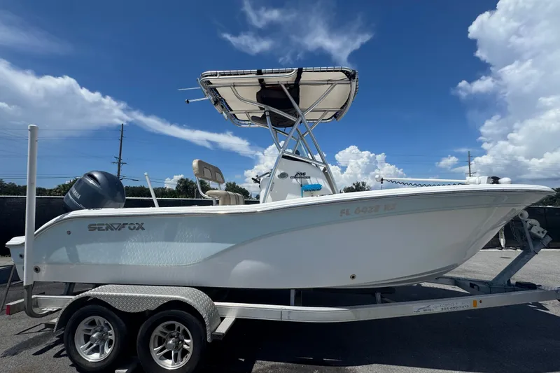 Slide: The Image of A 2016 Sea Fox 206 Commander on a trailer, featuring a T-top and outboard motor. - 1
