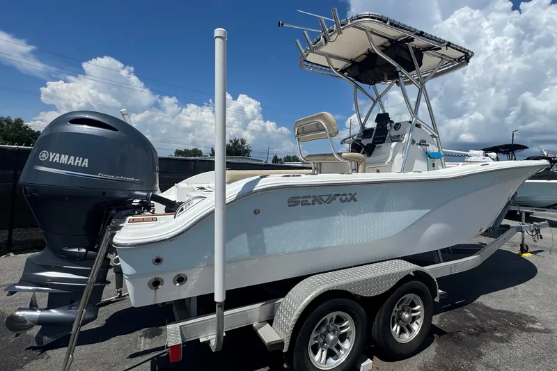 Slide: The Image of A 2016 Sea Fox 206 Commander on a trailer, featuring a Yamaha outboard motor, under a blue sky. - 2