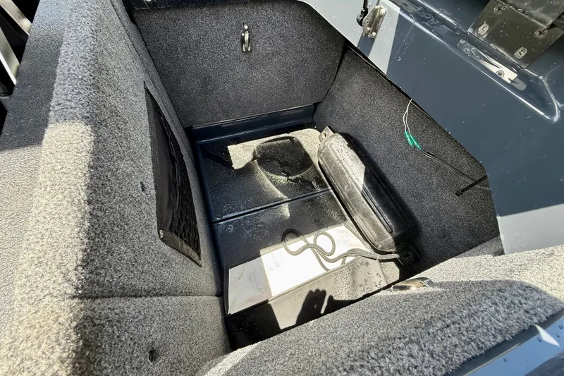 Slide: The Image of Interior storage compartment of 2022 Supra SE 450 boat, featuring carpeted surfaces and equipment. - 32