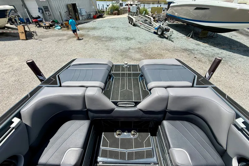 Slide: The Image of 2022 Supra SE 450 boat interior with gray seating at a marina. - 12