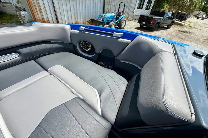 Slide: The Image of 2022 Supra SE 450 boat interior with gray and blue seating, outdoor setting. - 25
