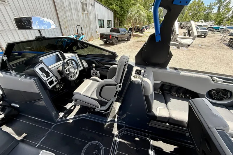 Slide: The Image of 2022 Supra SE 450 boat interior with modern dashboard and seating, parked outdoors. - 14