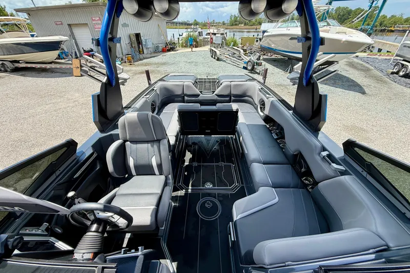 Slide: The Image of 2022 Supra SE 450 boat interior with sleek seating and modern design at a marina. - 23
