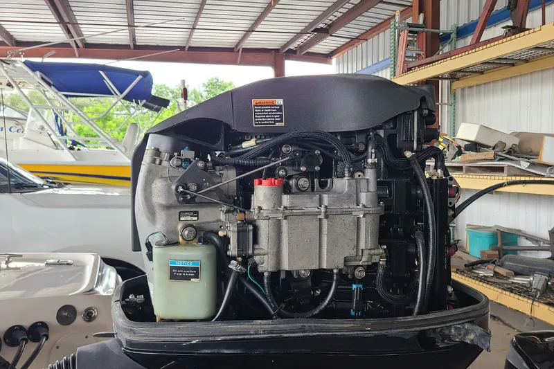 Slide: The Image of 1994 Checkmate Pulsare 2100 boat engine in a garage with tools and boats. - 22