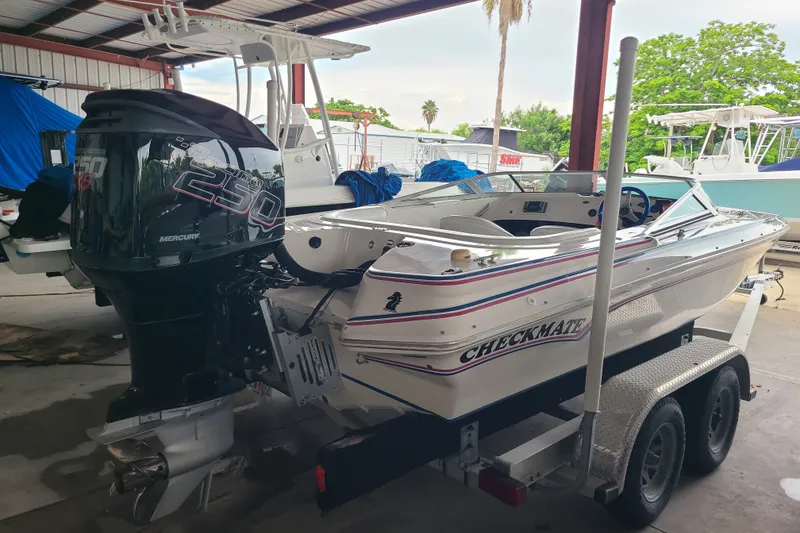 Slide: The Image of 1994 Checkmate Pulsare 2100 boat with Mercury 250 engine on trailer in covered storage. - 19