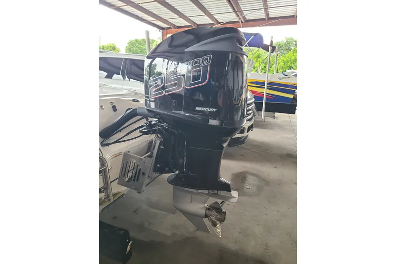 Slide: The Image of 1994 Checkmate Pulsare 2100 with Mercury 250 outboard motor in a covered area. - 21
