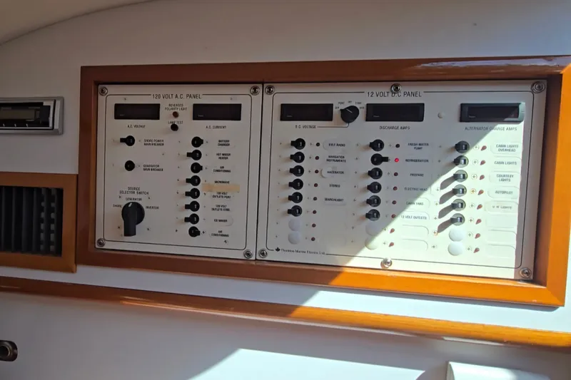 Slide: The Image of Electrical control panel on a 2006 Bruckmann Bluestar 37 boat, featuring AC and DC switches. - 50