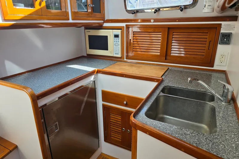 Slide: The Image of Galley kitchen in 2006 Bruckmann Bluestar 37 yacht with wood cabinets and stainless steel sink. - 40
