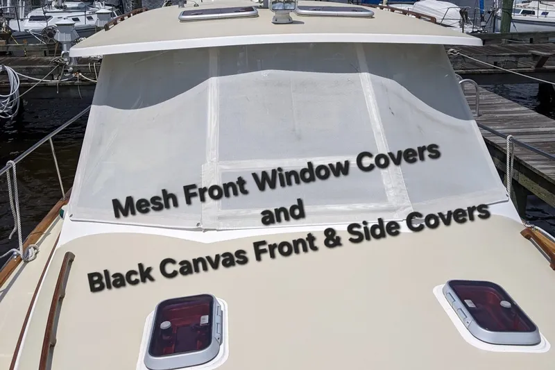 Slide: The Image of Bruckmann Bluestar 37 boat with mesh front window covers, docked in a marina. - 16