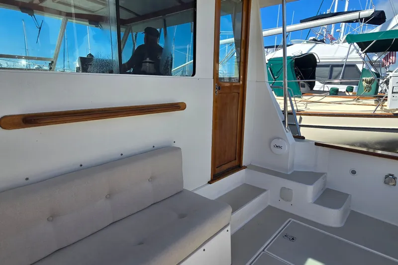 Slide: The Image of 2006 Bruckmann Bluestar 37 boat interior with cushioned seating and wooden door. - 20