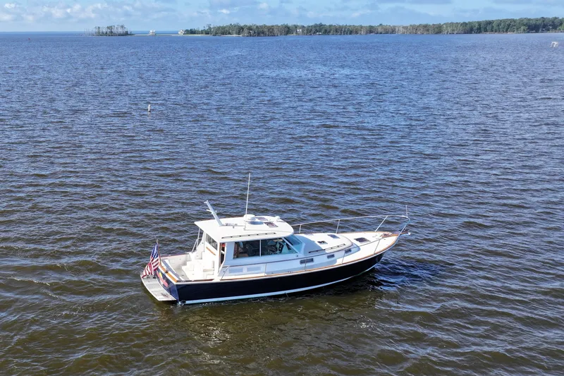 Slide: The Image of 2006 Bruckmann Bluestar 37 yacht on open water, clear sky, distant shoreline. - 53