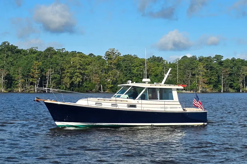 The Image of 2006 Bruckmann Bluestar 37 boat on a serene lake with forested background. - 1