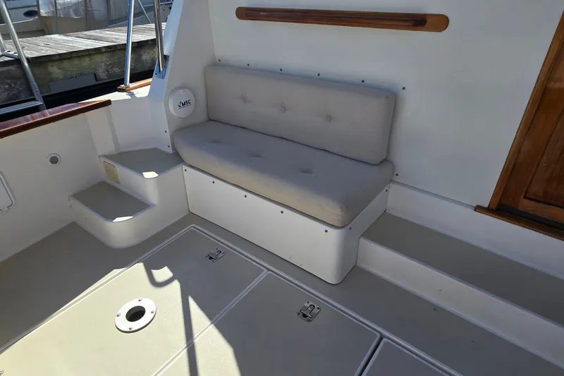 Slide: The Image of Interior seating area of a 2006 Bruckmann Bluestar 37 boat, featuring cushioned bench and steps. - 18
