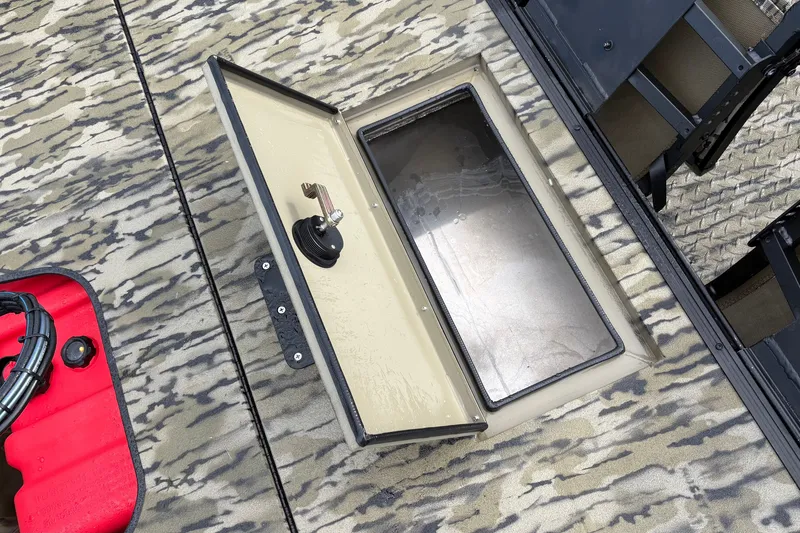 Slide: The Image of Open storage compartment on 2027 SeaArk Shadow 17 boat with camouflage flooring. - 8