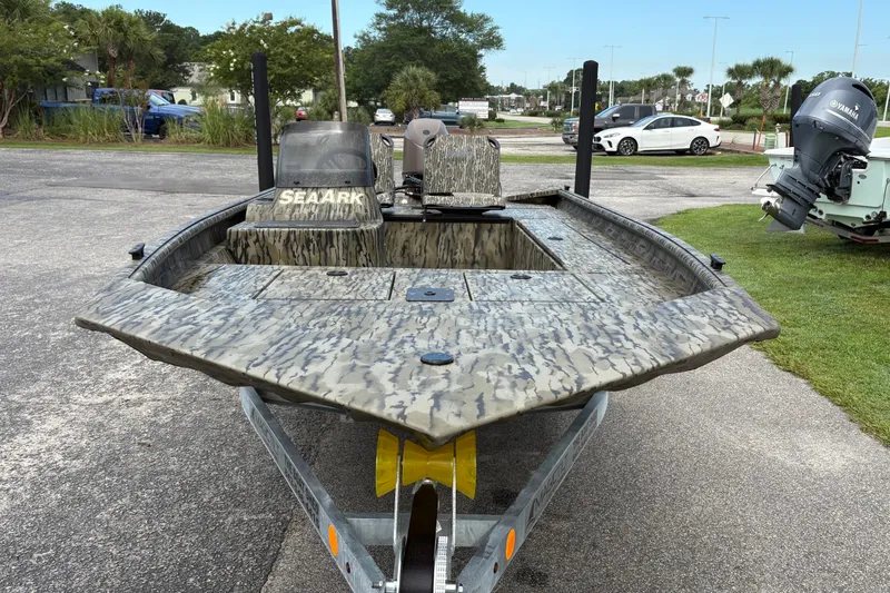 Slide: The Image of 2027 SeaArk Shadow 17 boat with camouflage design on a trailer in a parking area. - 4