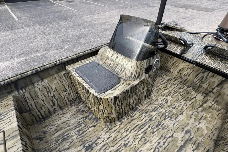 Slide: The Image of 2027 SeaArk Shadow 17 boat with camouflage design and windshield in a parking lot. - 12