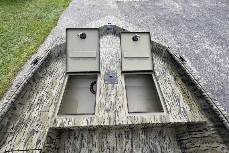 Slide: The Image of 2027 SeaArk Shadow 17 boat with open storage compartments on a patterned deck. - 14