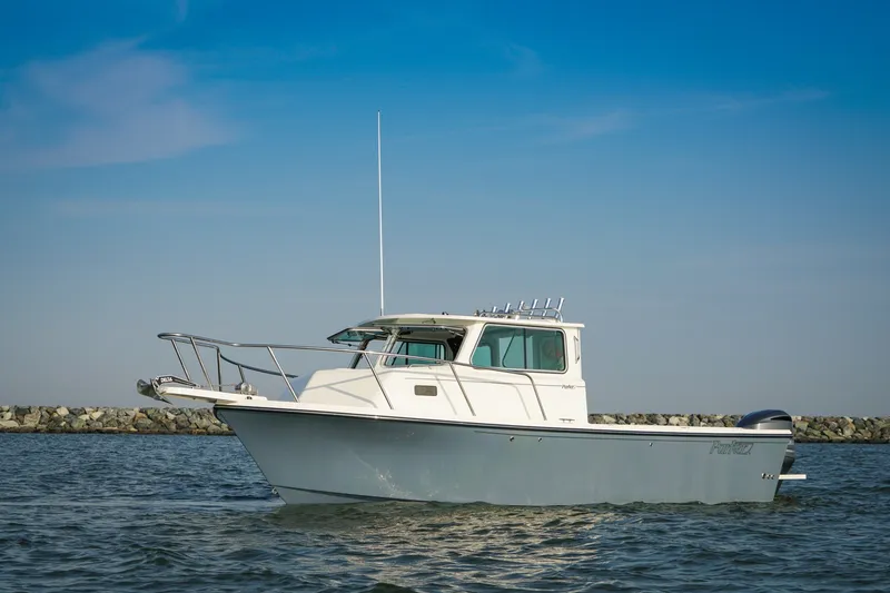 The Image of 2027 Parker 257 Explorer boat on calm water under clear blue sky. - 1