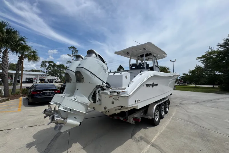 Slide: The Image of 2026 NauticStar 332 Offshore boat with dual outboard engines on a trailer. - 14