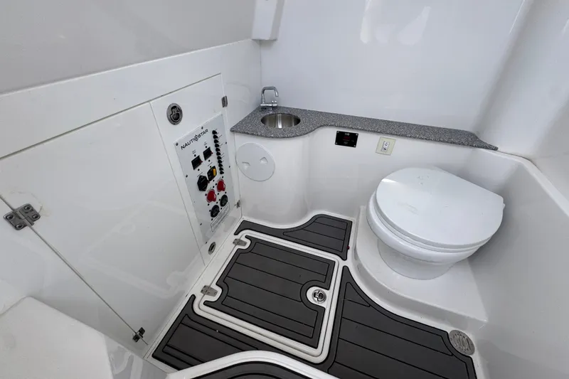 Slide: The Image of 2026 NauticStar 332 Offshore boat bathroom with sink, toilet, and control panel. - 31