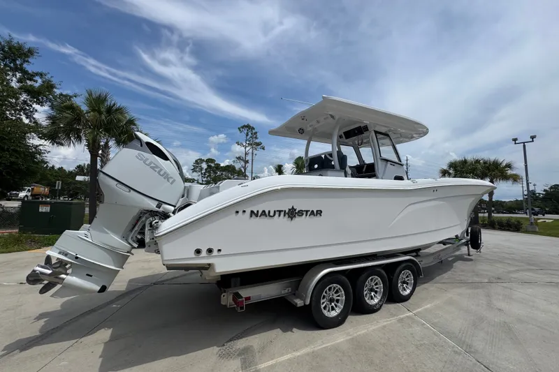 Slide: The Image of 2026 NauticStar 332 Offshore boat on trailer, featuring dual Suzuki engines. - 13