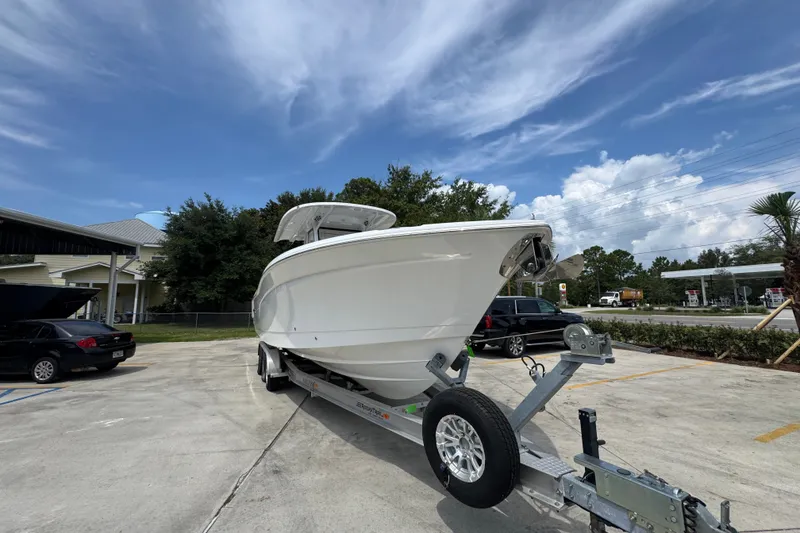 Slide: The Image of 2026 NauticStar 332 Offshore boat on trailer, parked outdoors under a clear sky. - 8